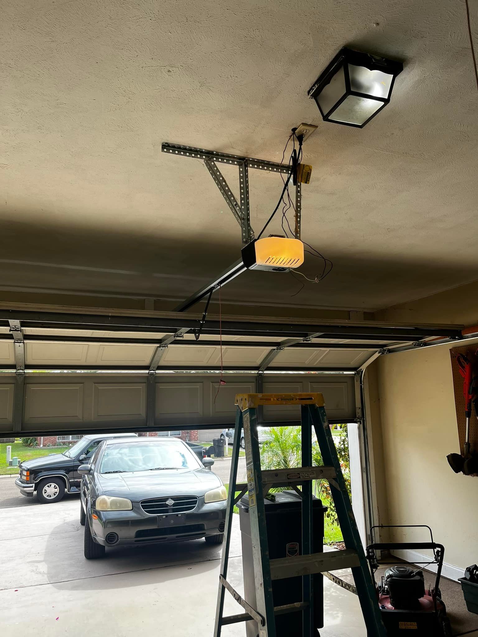 A car is parked in a garage next to a ladder.