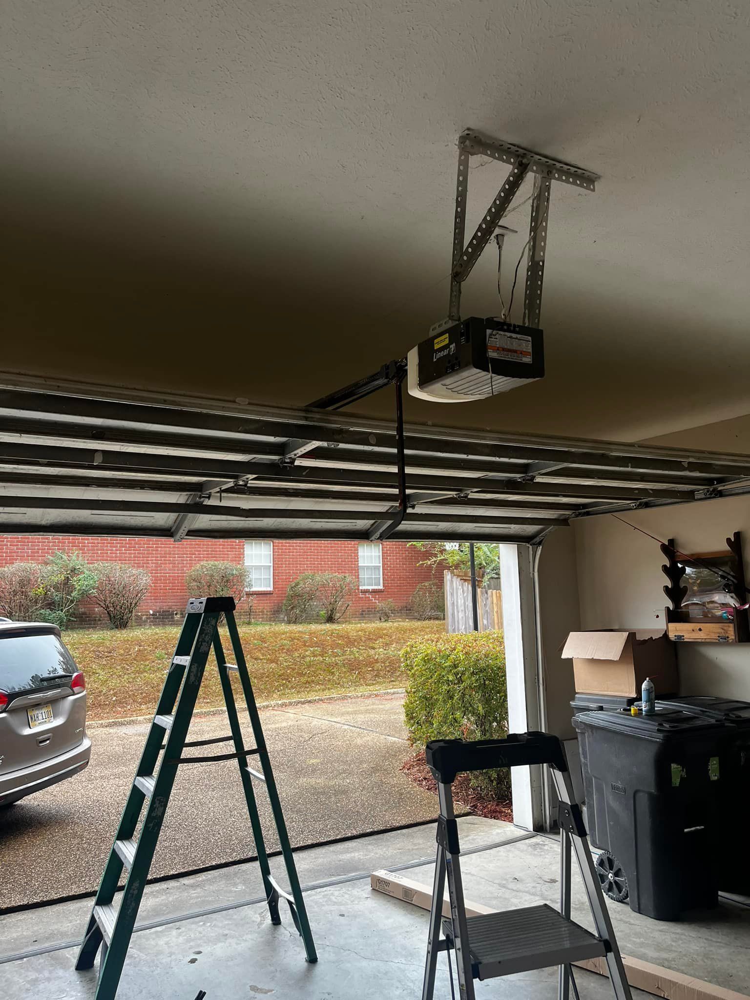 A garage with a ladder and a garage door opener.