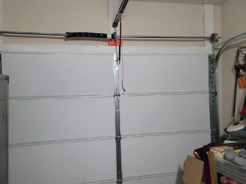 A garage door with a garage door opener hanging from it.