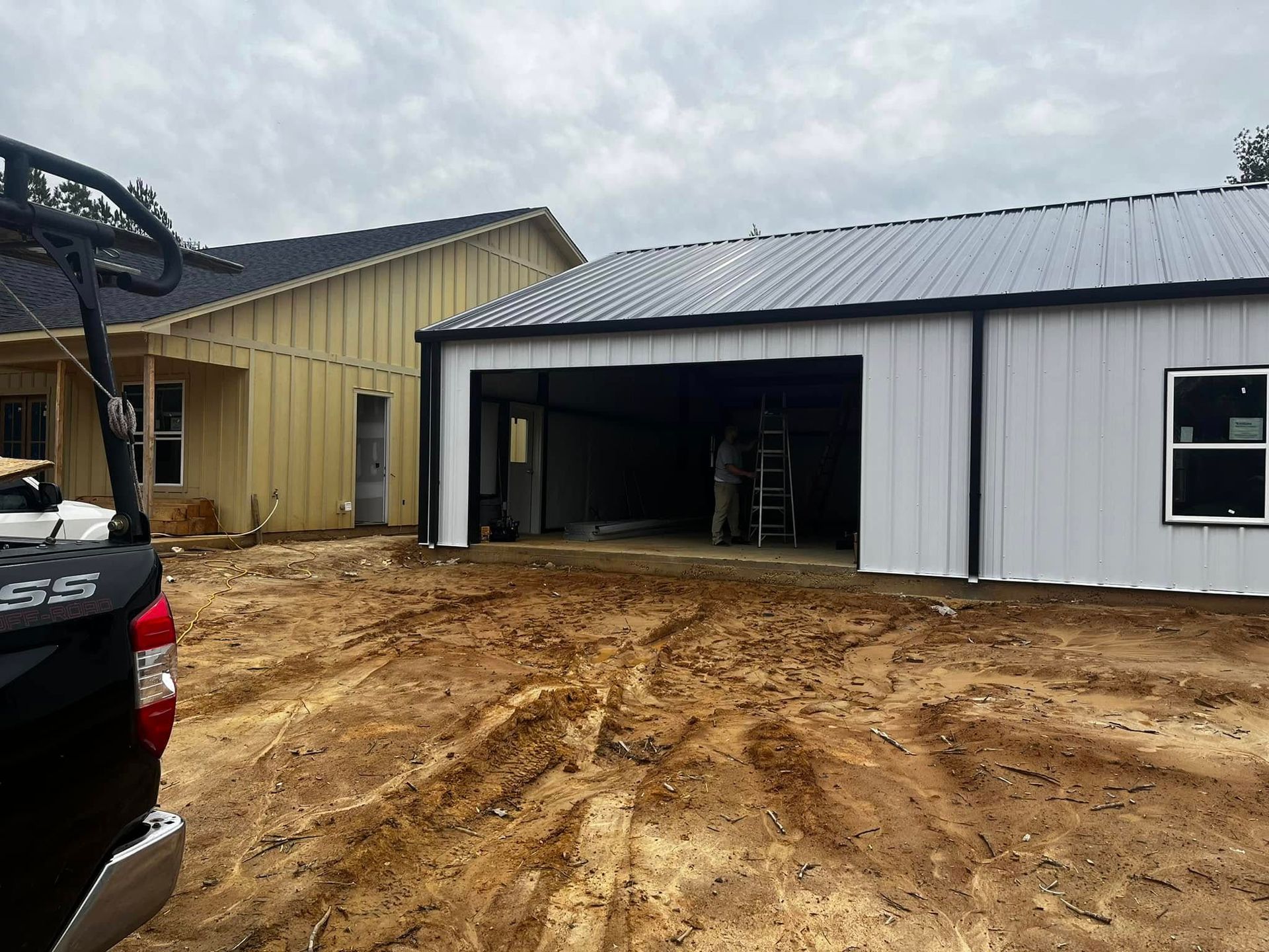 A truck is parked in front of a garage under construction.