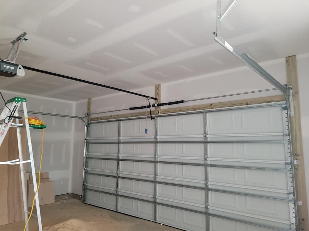 A garage with a garage door open and a ladder.