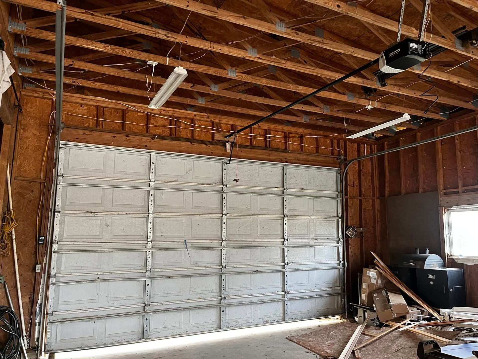 A garage with a garage door open and a garage door opener.