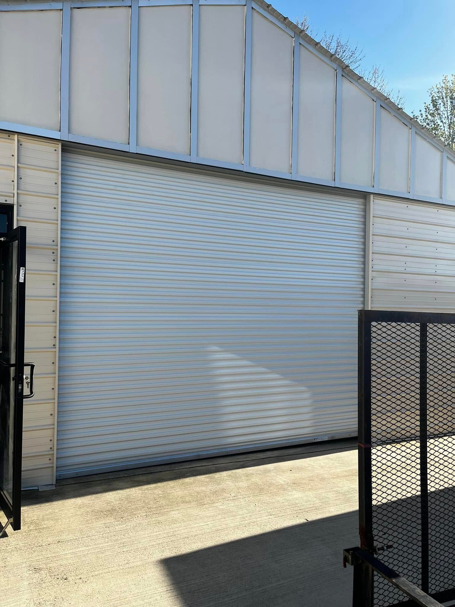 A white garage door with a black gate in front of it.