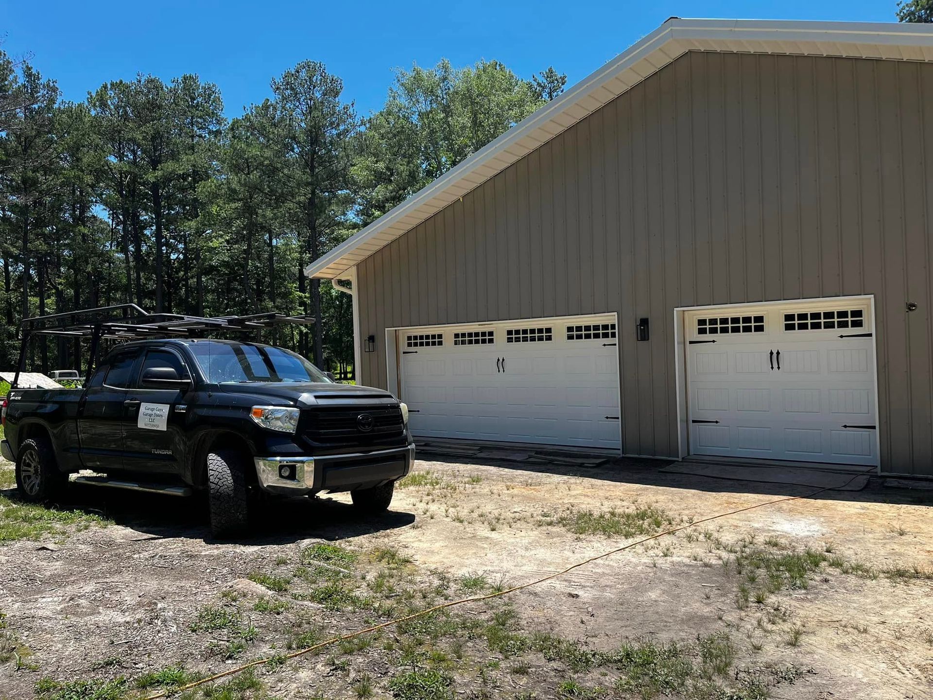 A black truck is parked in front of a garage.