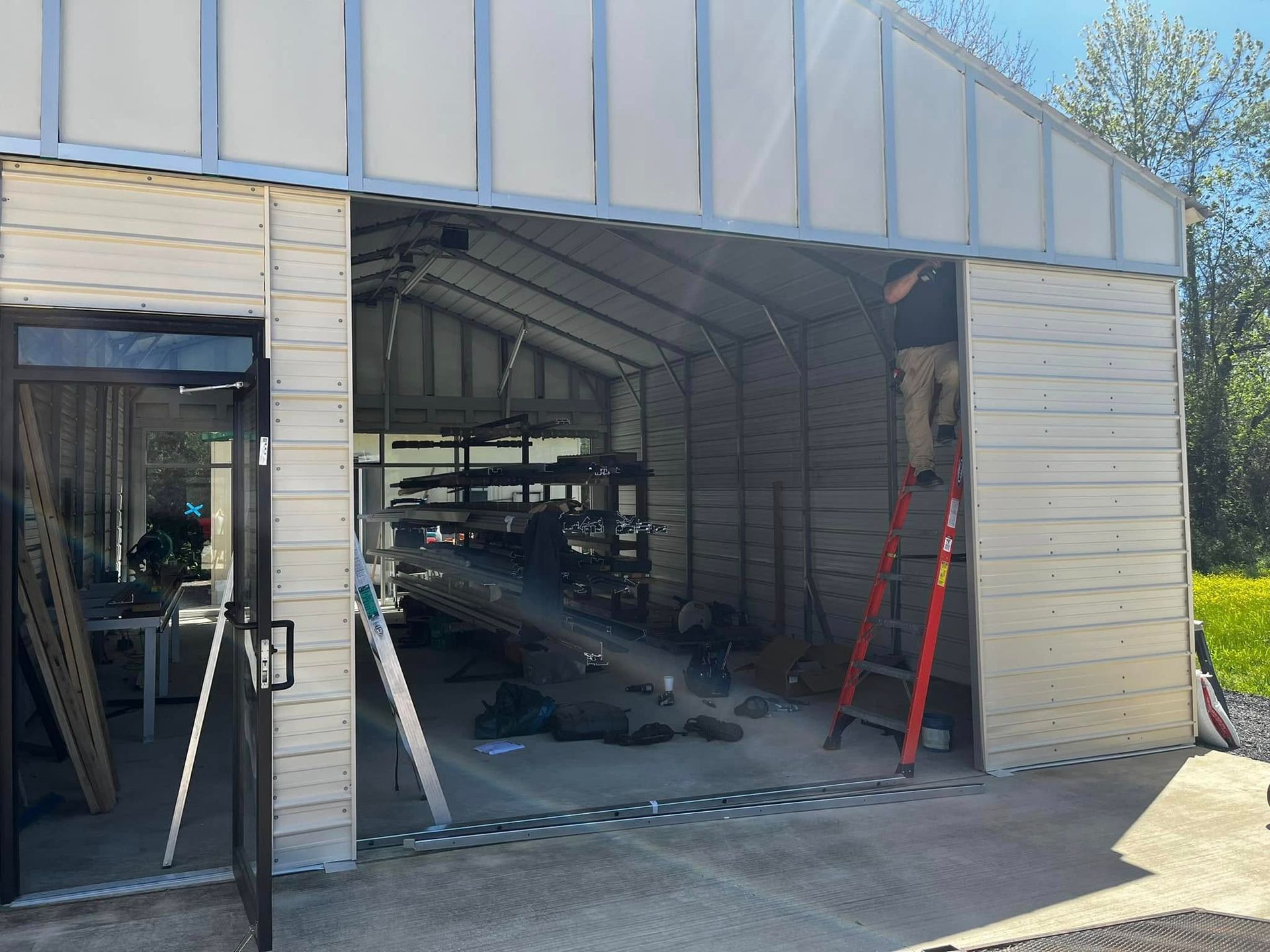 A man is standing on a ladder in a garage.