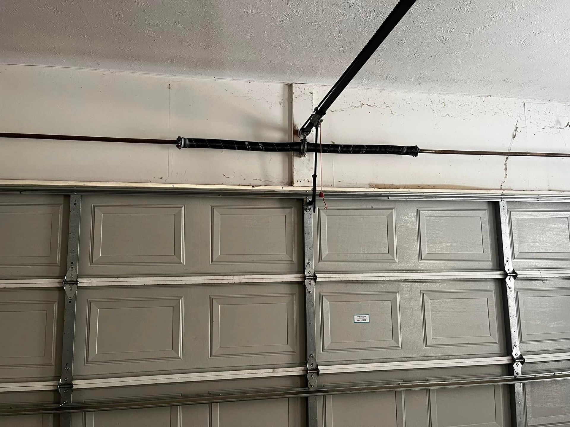 A garage door with a spring hanging from the ceiling.