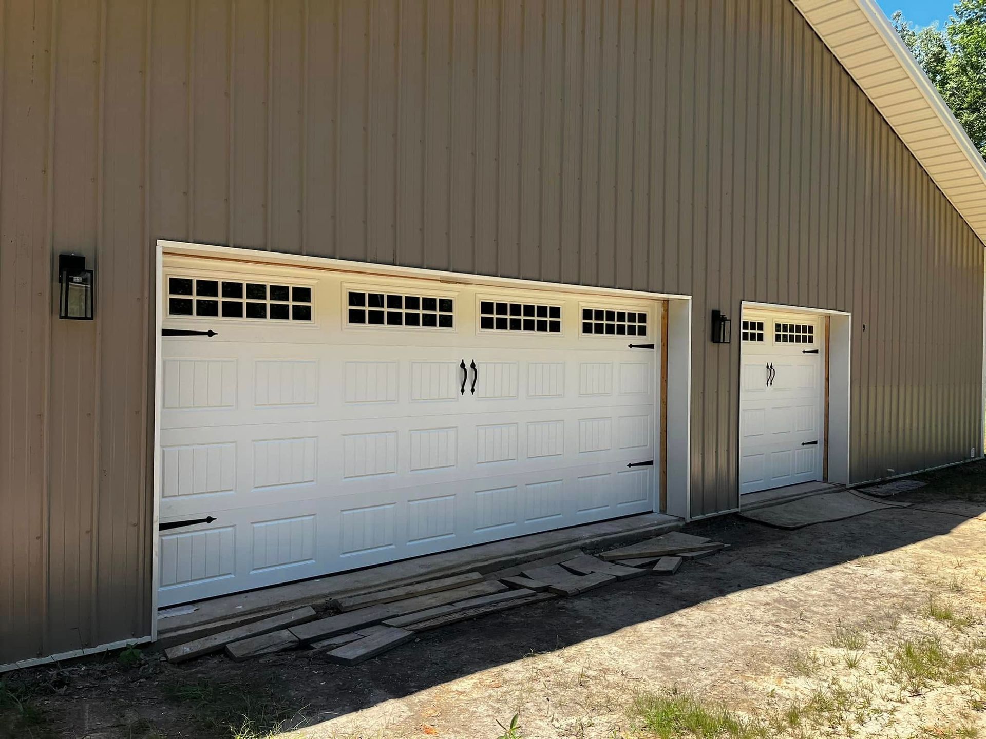 There are three garage doors on the side of a building.