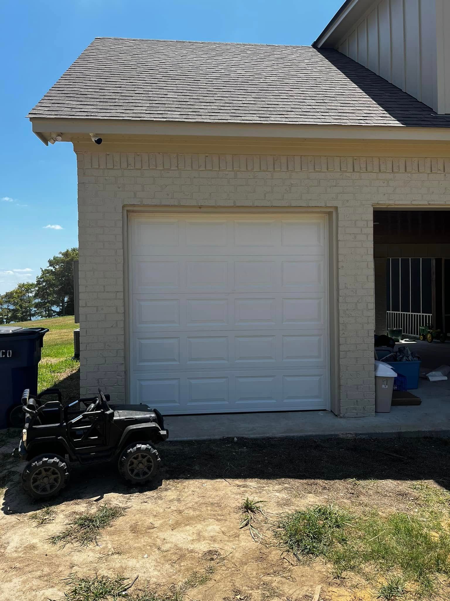 A toy car is parked in front of a garage door.