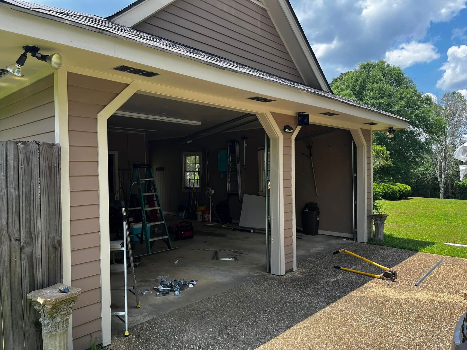A garage with a ladder and a shovel in it is being remodeled.