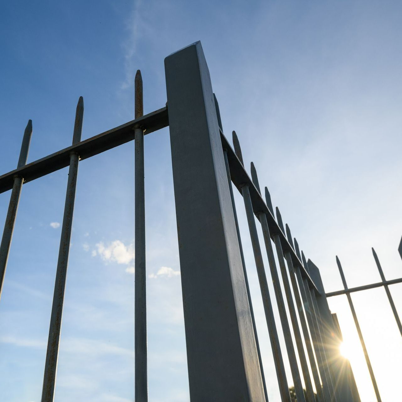 Metal fence against blue sky