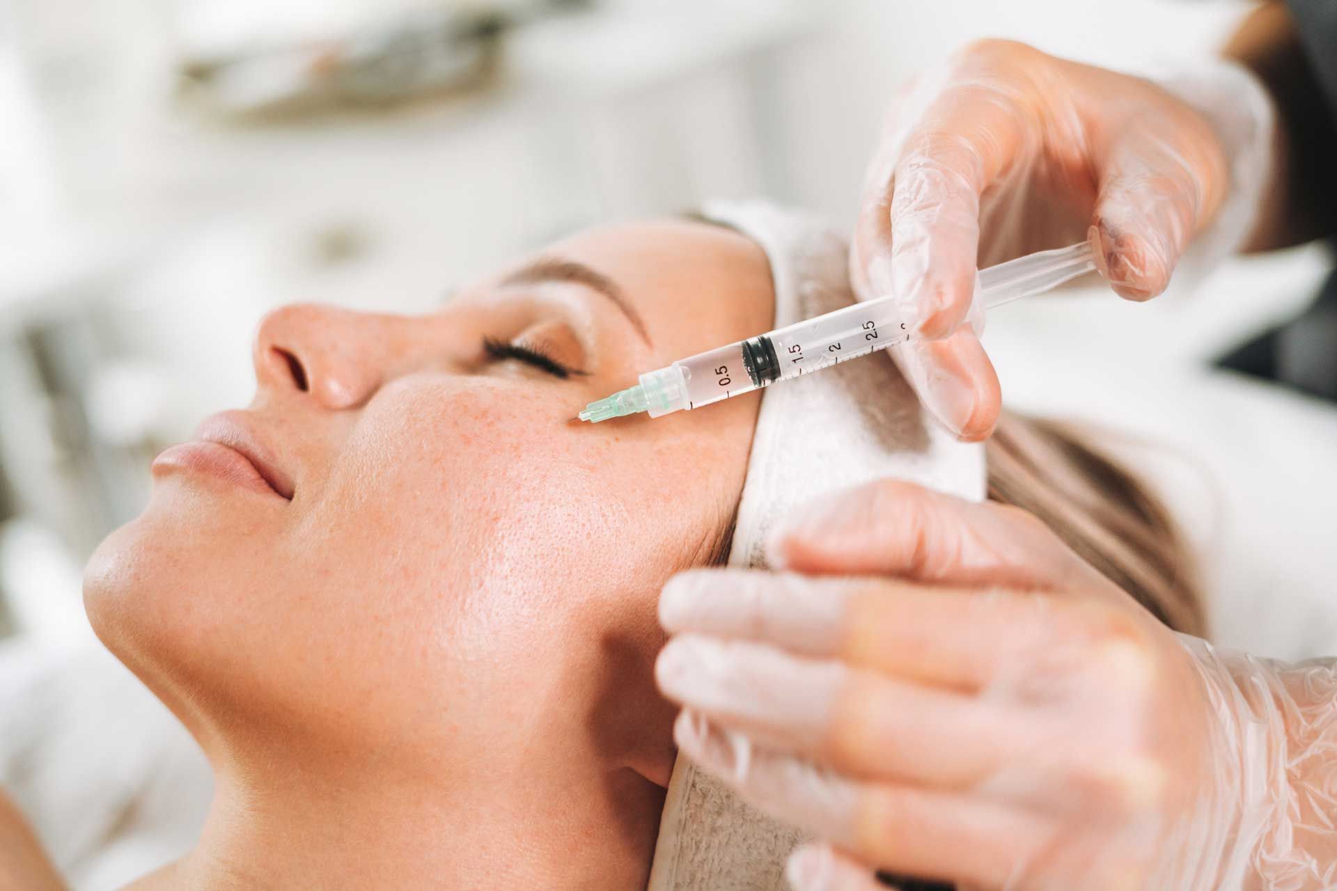 Young woman getting cosmetic injections in her face