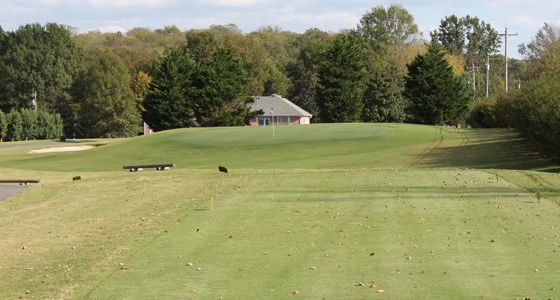 A golf course with a house in the background