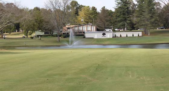 A golf course with a fountain in the middle of it.
