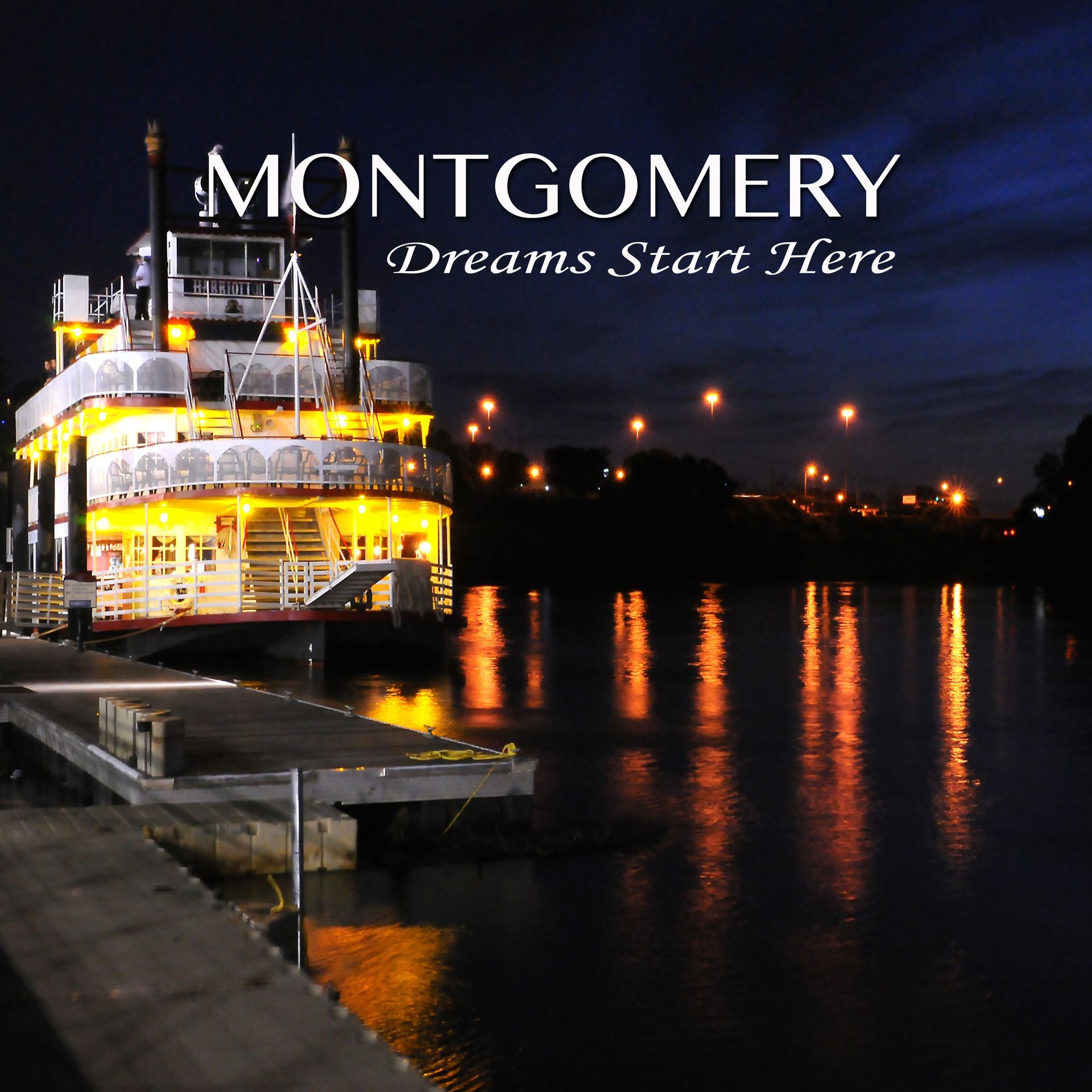 Riverboat illuminated at night in Montgomery, Alabama, with reflections on the water.