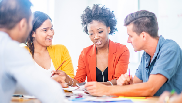 A group of people are sitting around a table having a meeting.