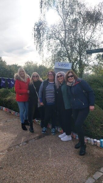 A group of women are posing for a picture in a park.
