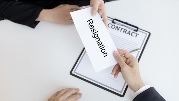 A person is handing a resignation letter to another person.