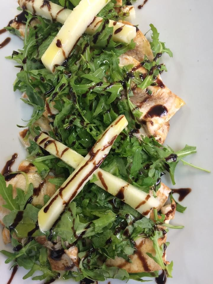 Insalata di pollo grigliato con rucola, fette di mela e glassa balsamica.