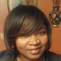 A close up of a woman 's face with a vase in the background.