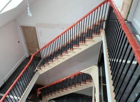 an aerial view of a staircase with a red railing .