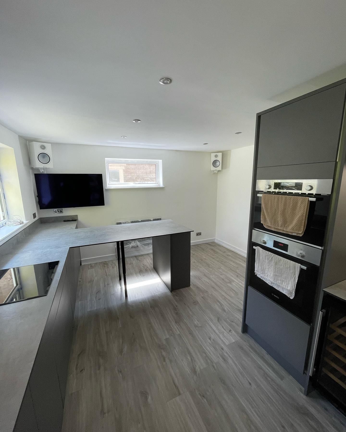 a kitchen with a large flat screen tv on the wall .