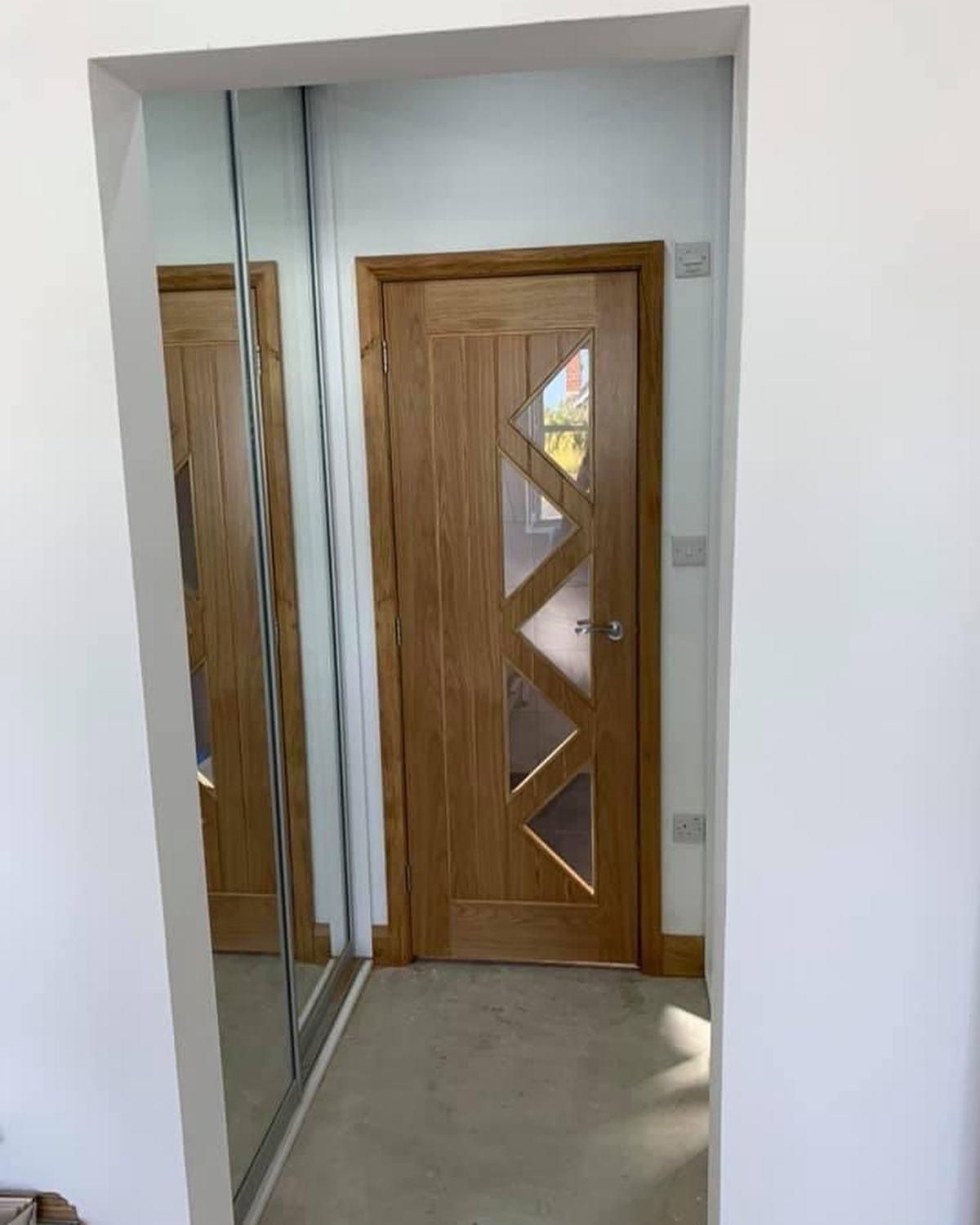 a hallway with a wooden door and a mirror .