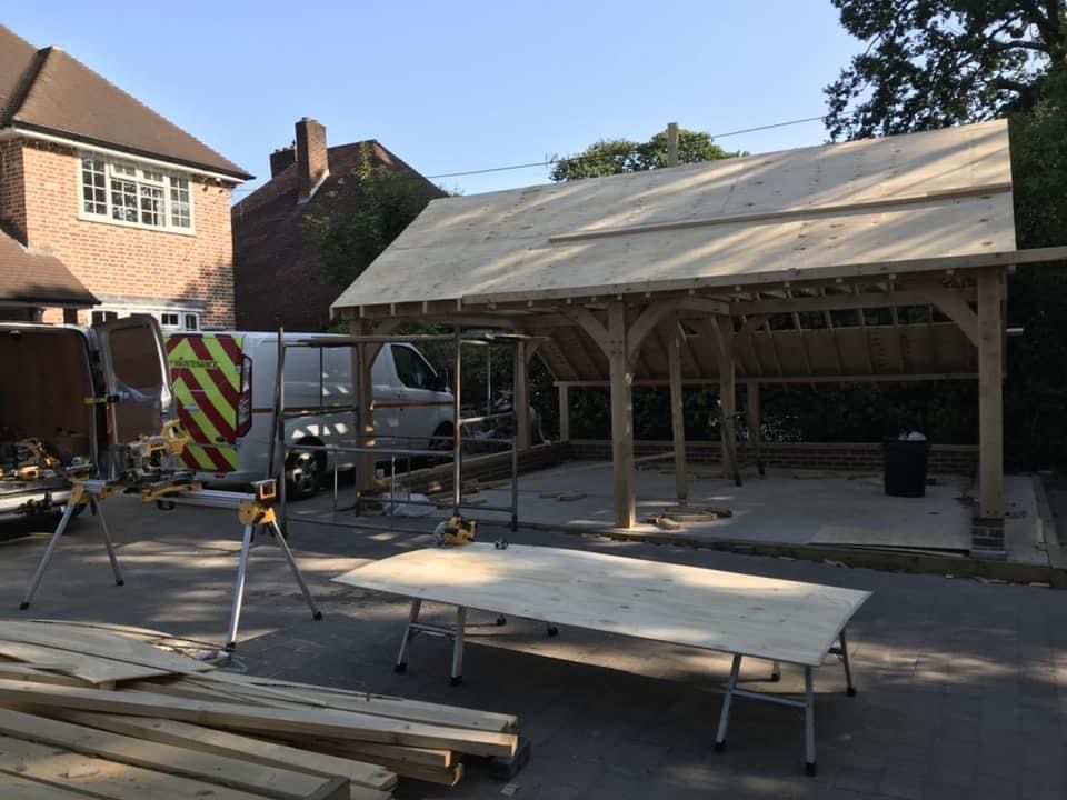 a wooden structure is being built in a driveway in front of a house .