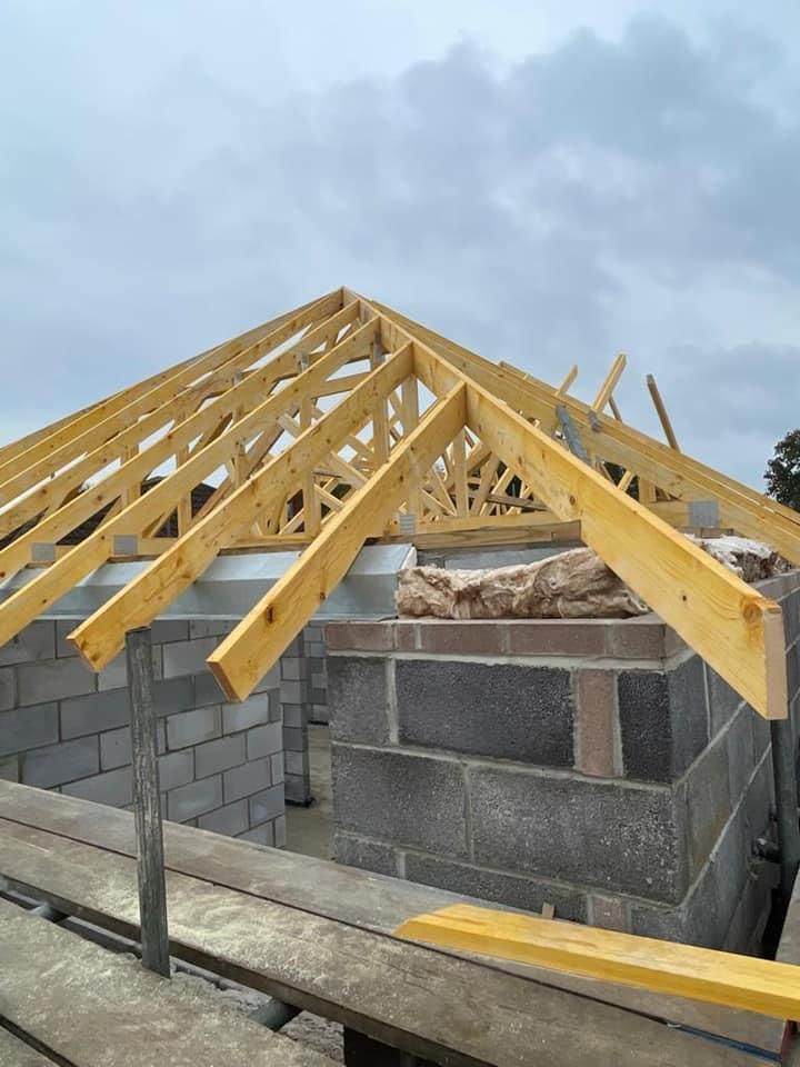 a wooden structure is being built on top of a brick building .