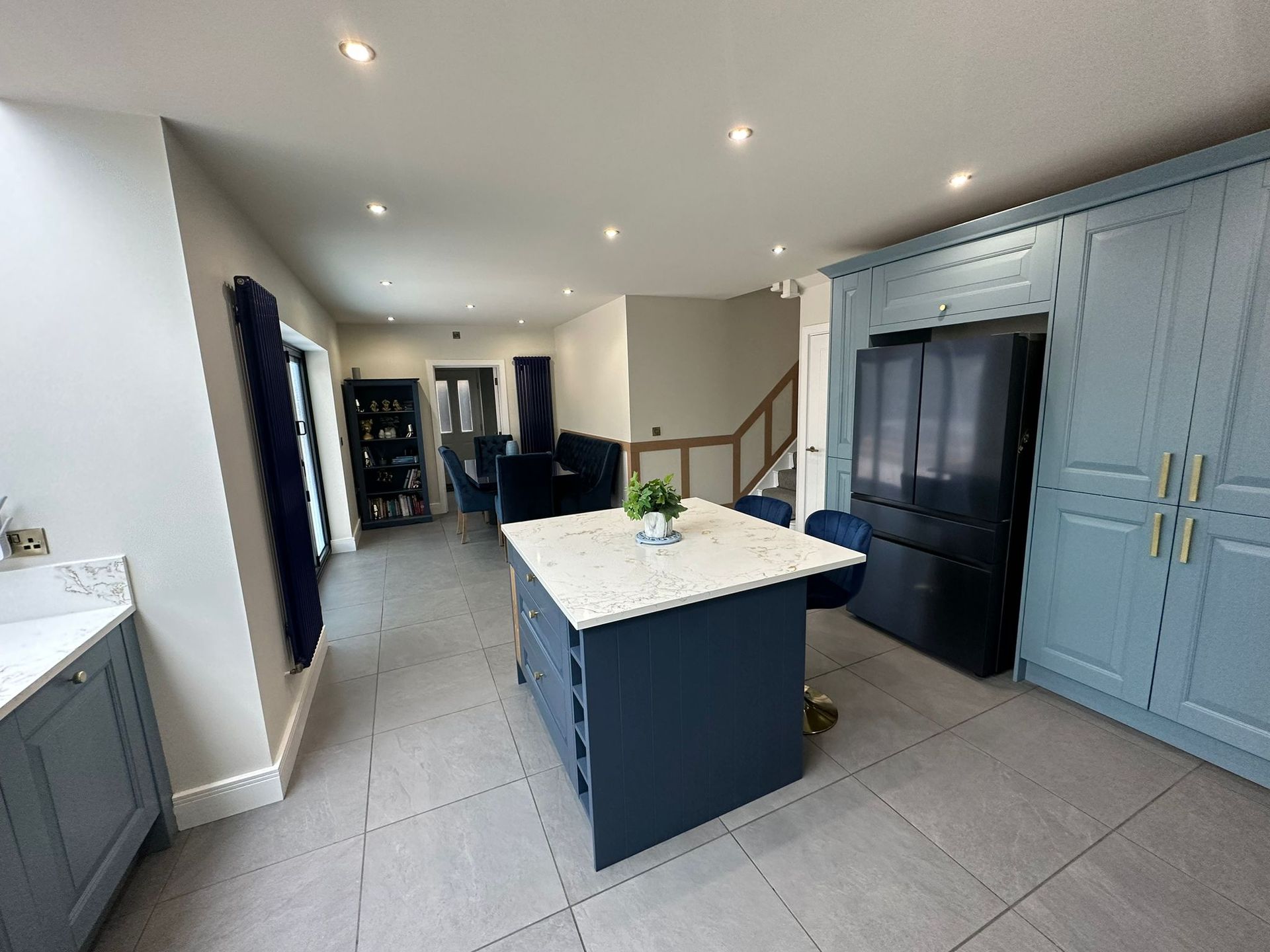 a kitchen with blue cabinets and a large island in the middle .
