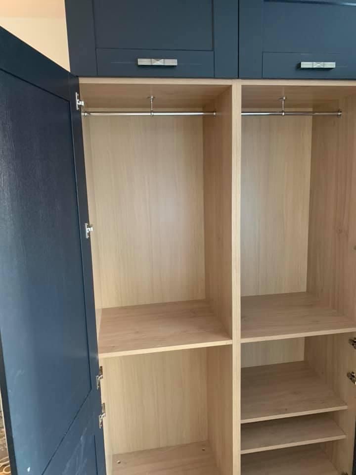 the inside of an empty wardrobe with the door open .