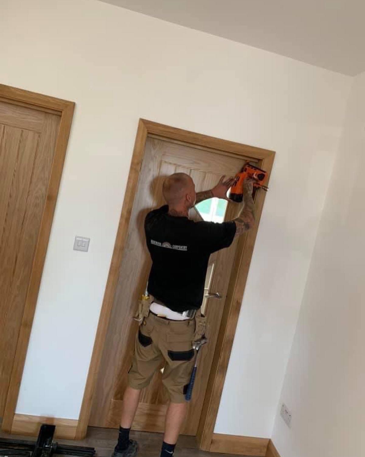 a man is working on a door with a drill .