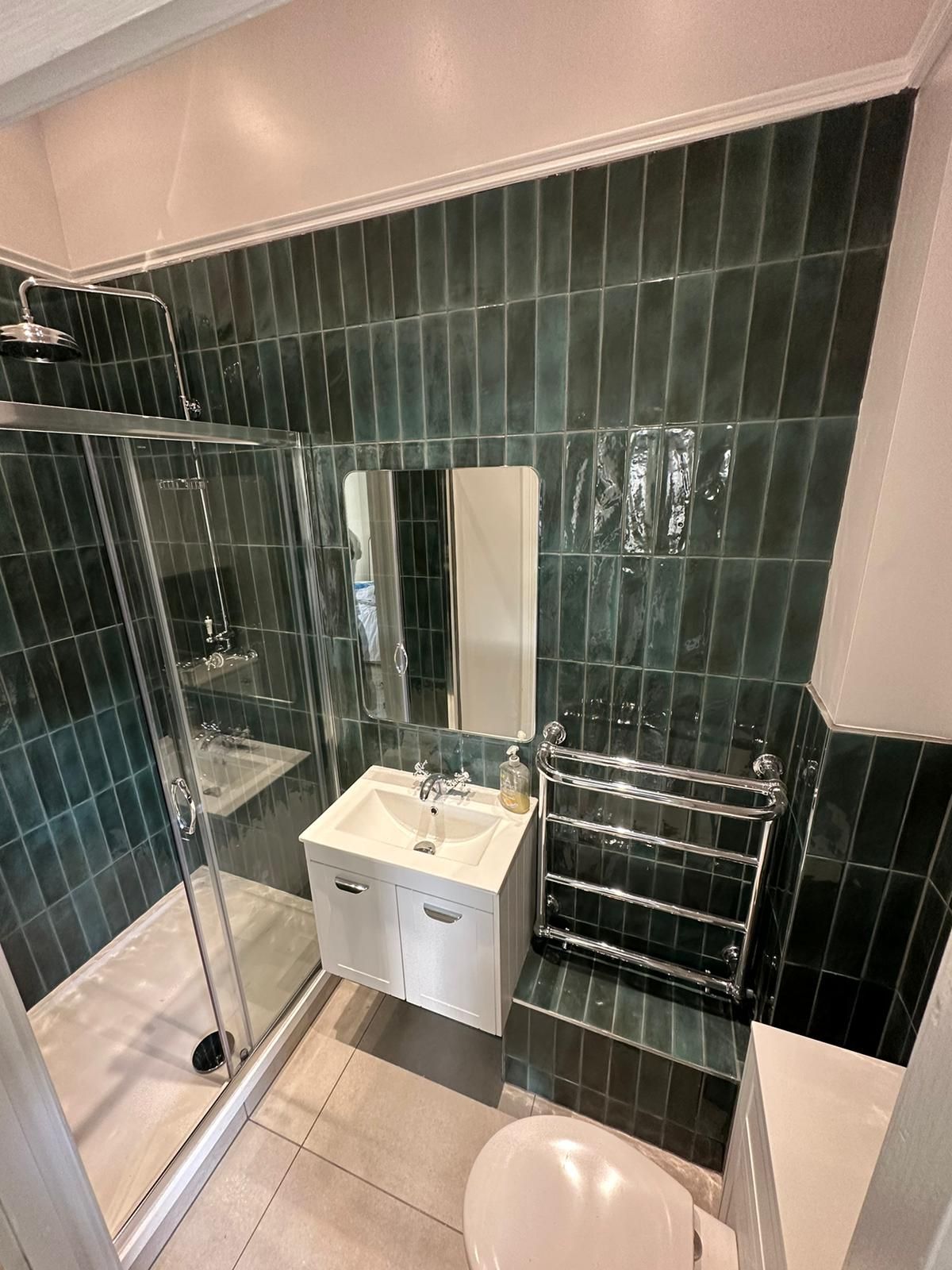 a bathroom with a sink , toilet , shower and mirror .