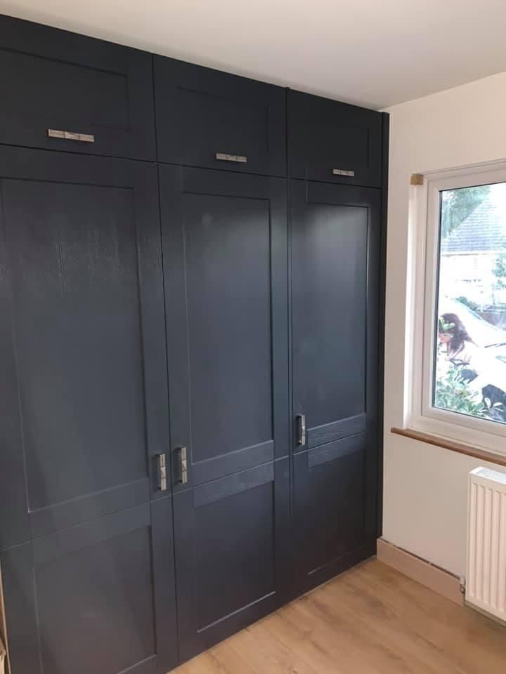 a bedroom with a large wardrobe and a window .