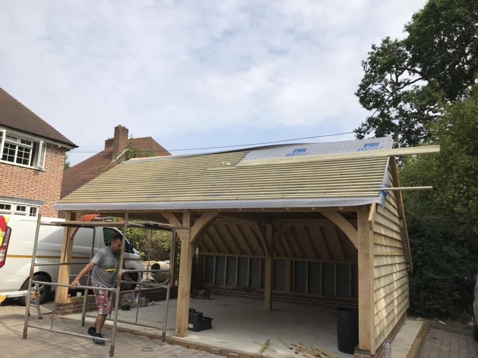 a man is working on the roof of a wooden garage .