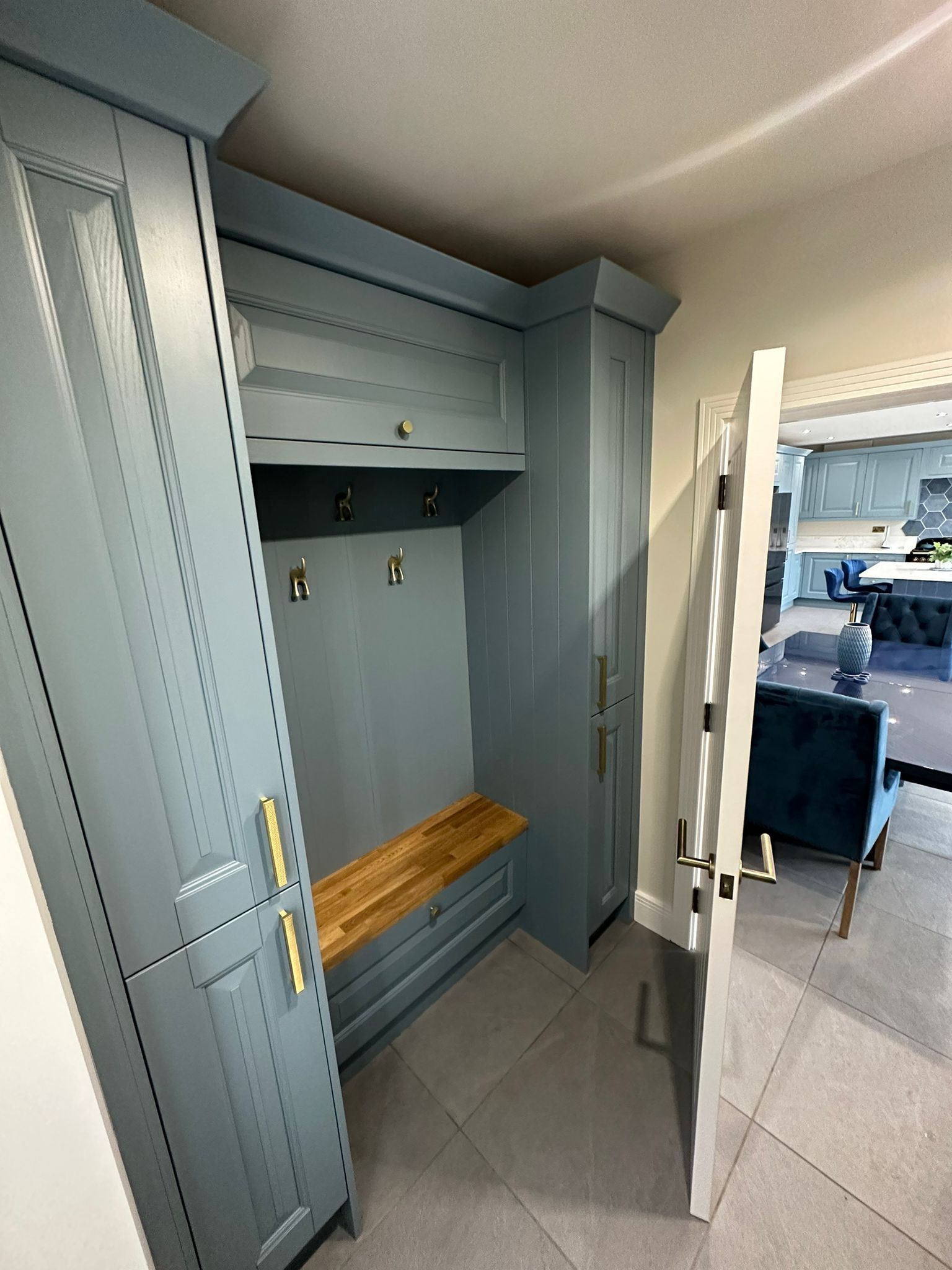 a hallway with blue cabinets and a wooden bench
