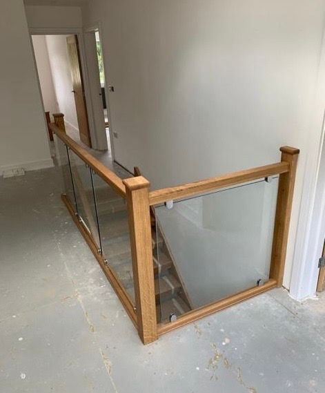 a wooden staircase with a glass railing in a hallway .