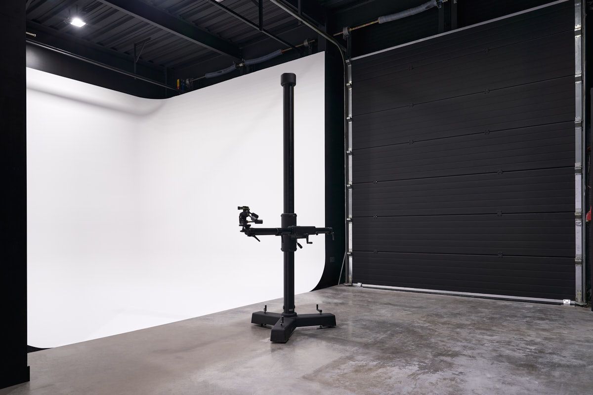 an empty room with a white wall and a black door .