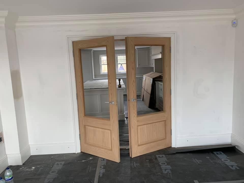 a pair of wooden doors are open in a room .