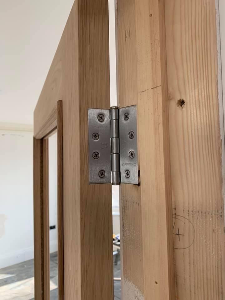 a close up of a door hinge on a wooden door .
