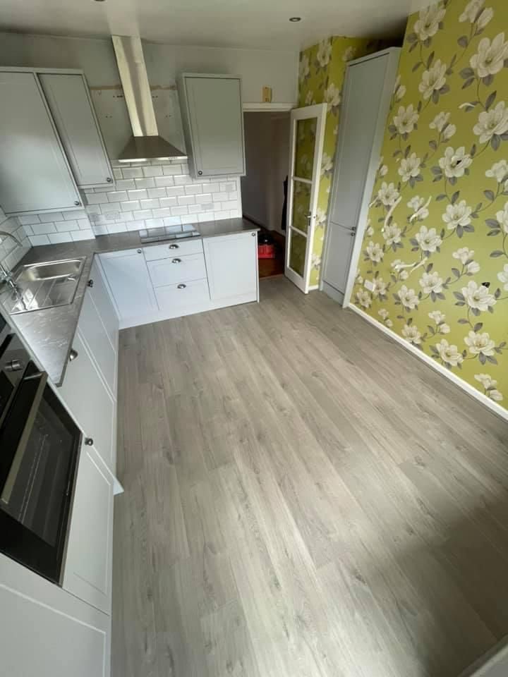 a kitchen with white cabinets , a sink , and a stove .