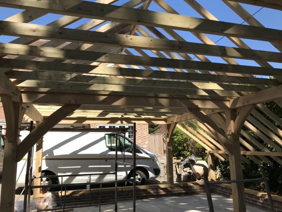 a white van is parked under a wooden structure .