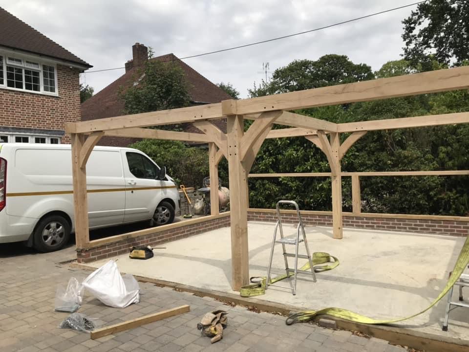 a white van is parked in a driveway next to a wooden structure .
