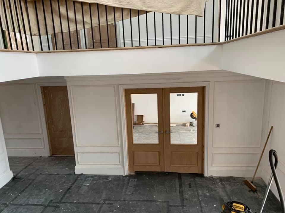 a room with a wooden door and a railing .