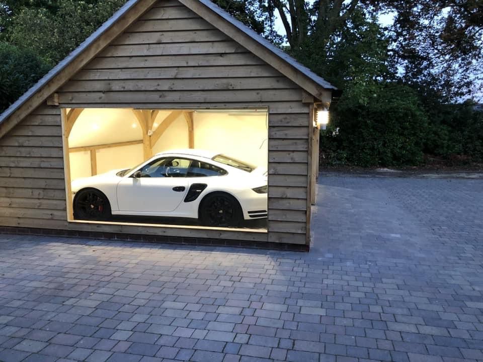 a white sports car is parked in a wooden garage .