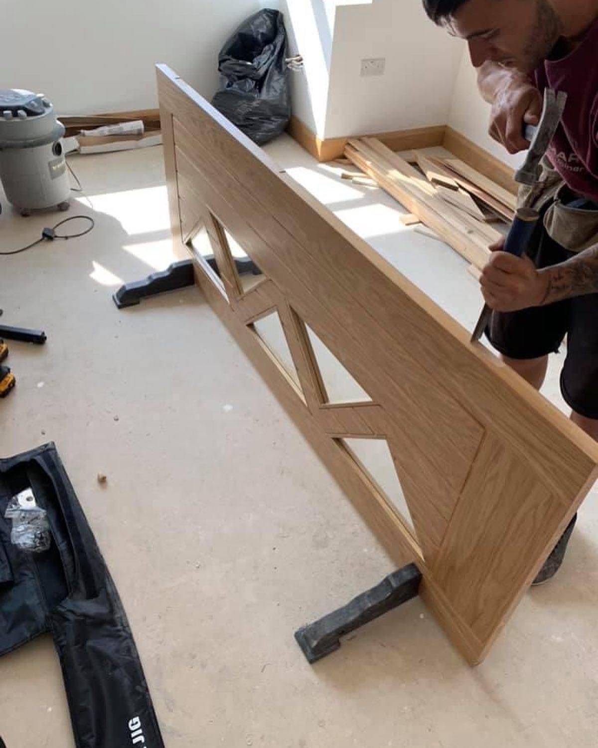 a man is working on a piece of wood in a room