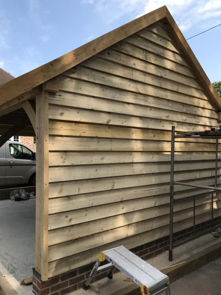 a wooden garage with a car parked underneath it .