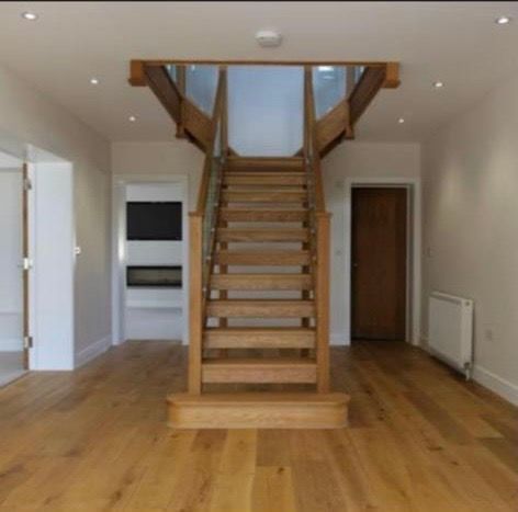 a wooden staircase in a hallway with hardwood floors