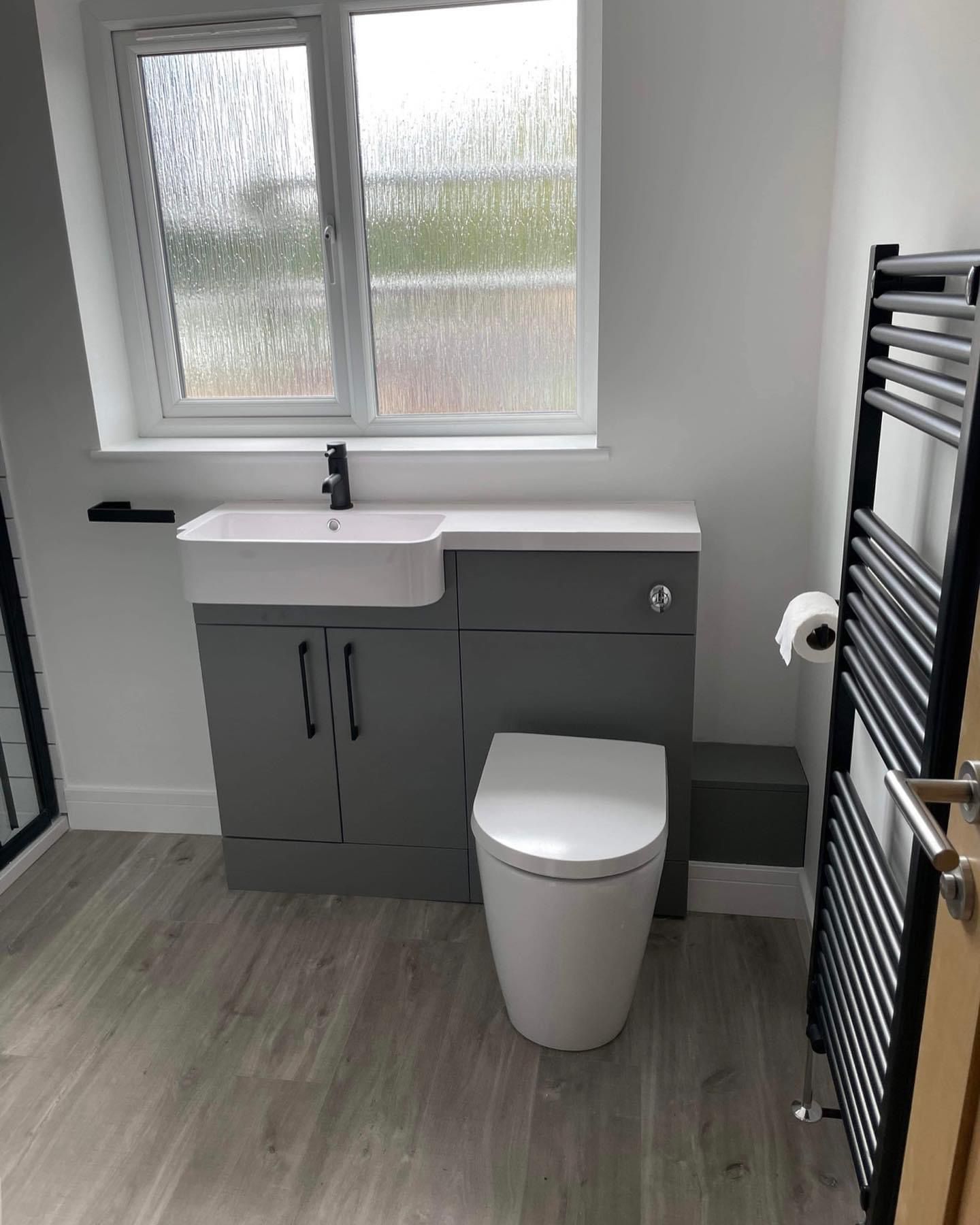 a bathroom with a toilet , sink , and towel rack .