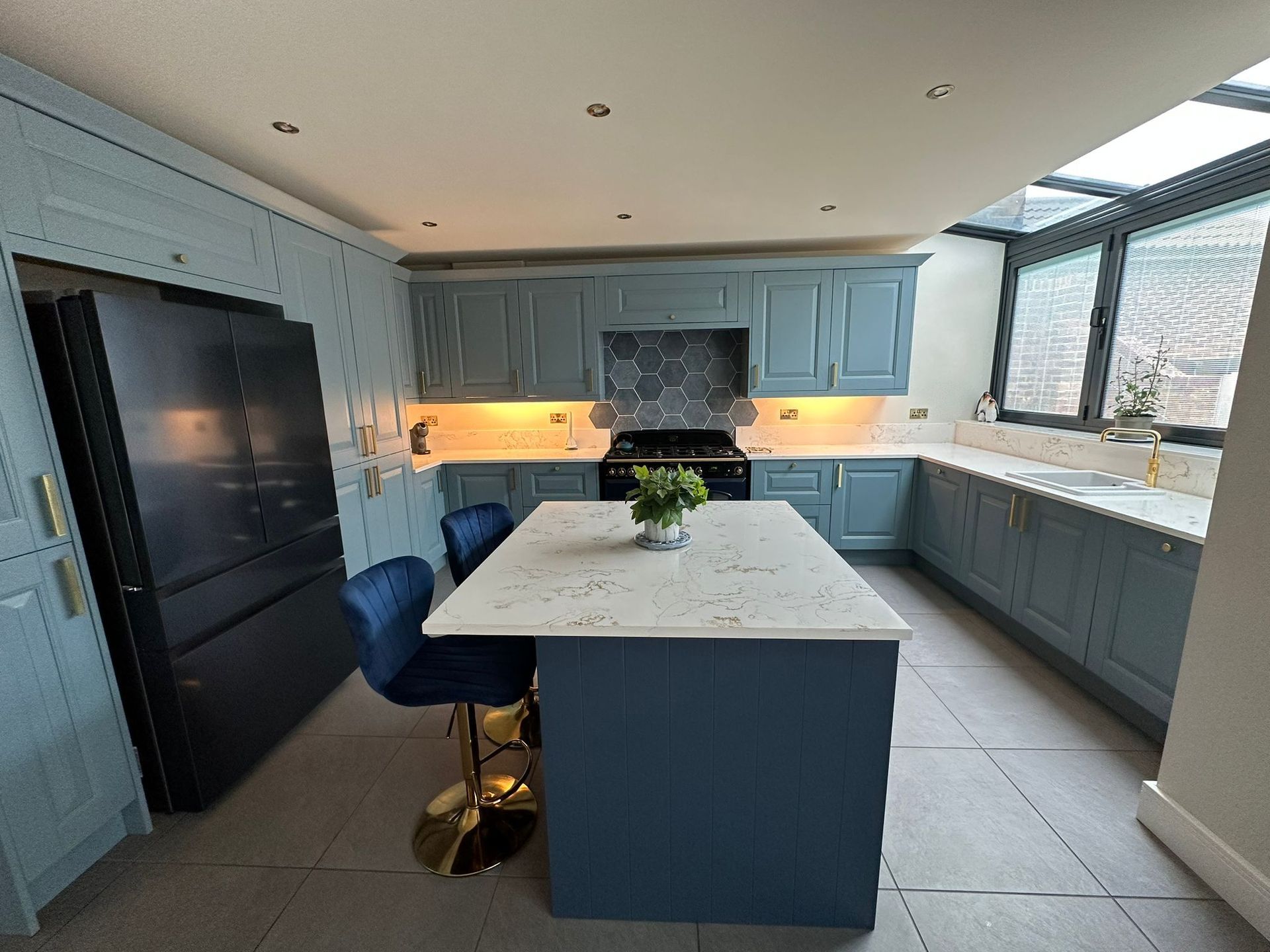 a kitchen with blue cabinets and a large island in the middle