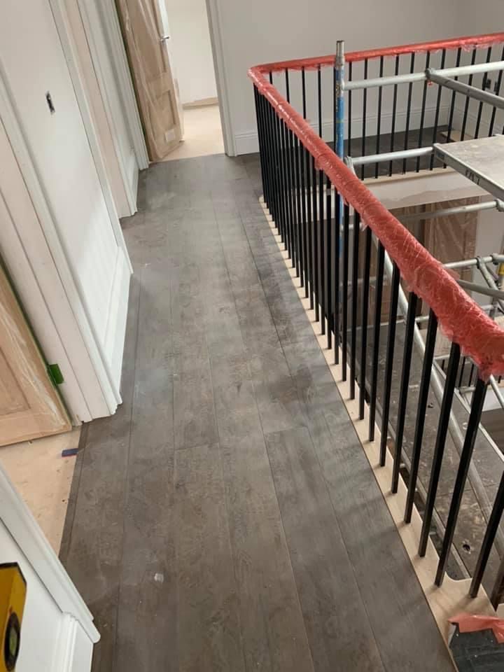a hallway with stairs and a railing in a house under construction .
